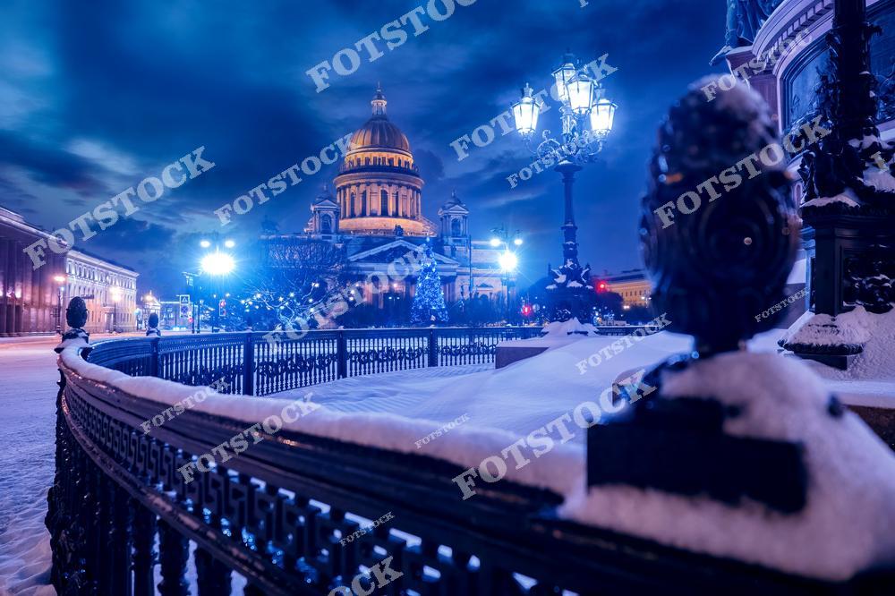 На фотографии изображен зимний Санкт-Петербург, покрытый снежным покровом. Исаакиевский собор величественно возвышается на фоне зимнего города, создавая атмосферу торжественности и покоя. Зимний пейзаж города, украшенный рождественскими огнями, отражает волшебство новогодних праздников. В снегах Петербурга ощущается дух праздника и красоты российской столицы накануне Нового года.